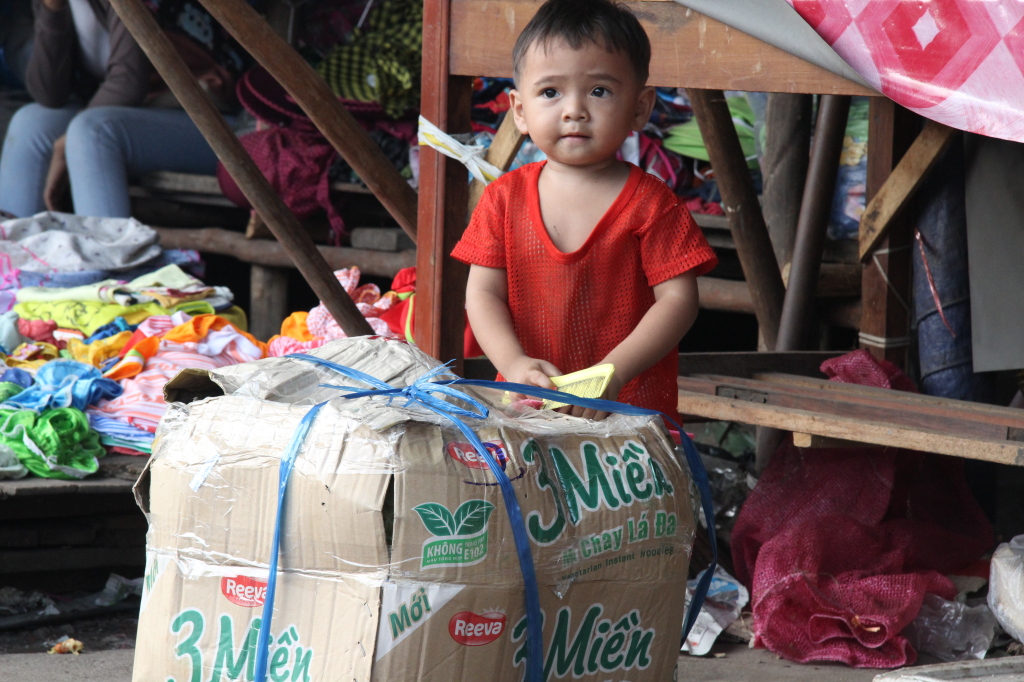 Versteckspiele hinter großen Paketen auf dem Markt in Sihanoukville