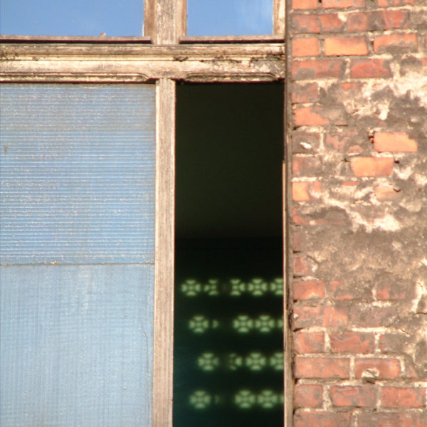 Lichtspiele im Fenster eines leer stehenden Hauses