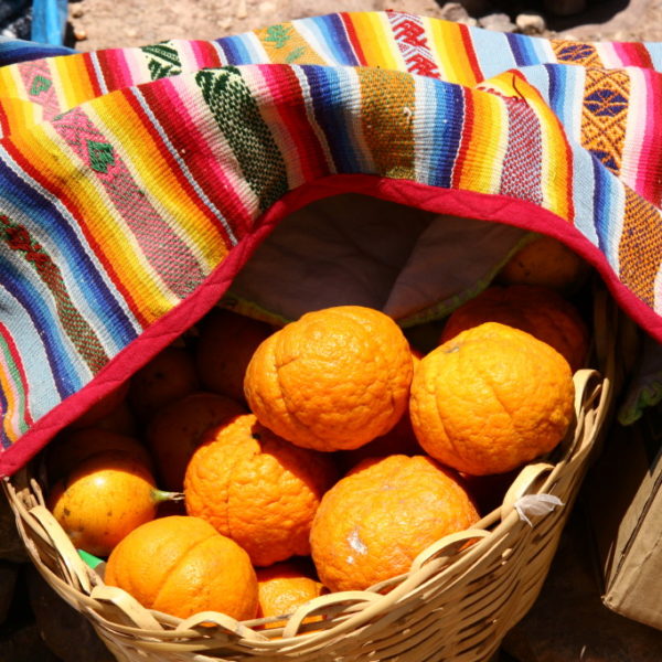 Frische Orangen unter buntem, peuanischen Tuch