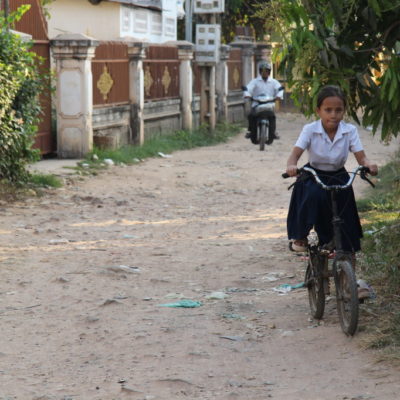 Schulmädchen in Uniform auf dem Fahrrad